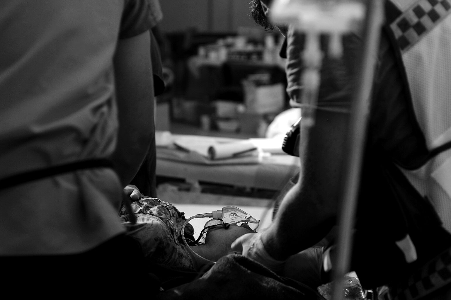 Eine Patientin wird auf einer Trage liegend beatmet und von zwei Personen behandelt.