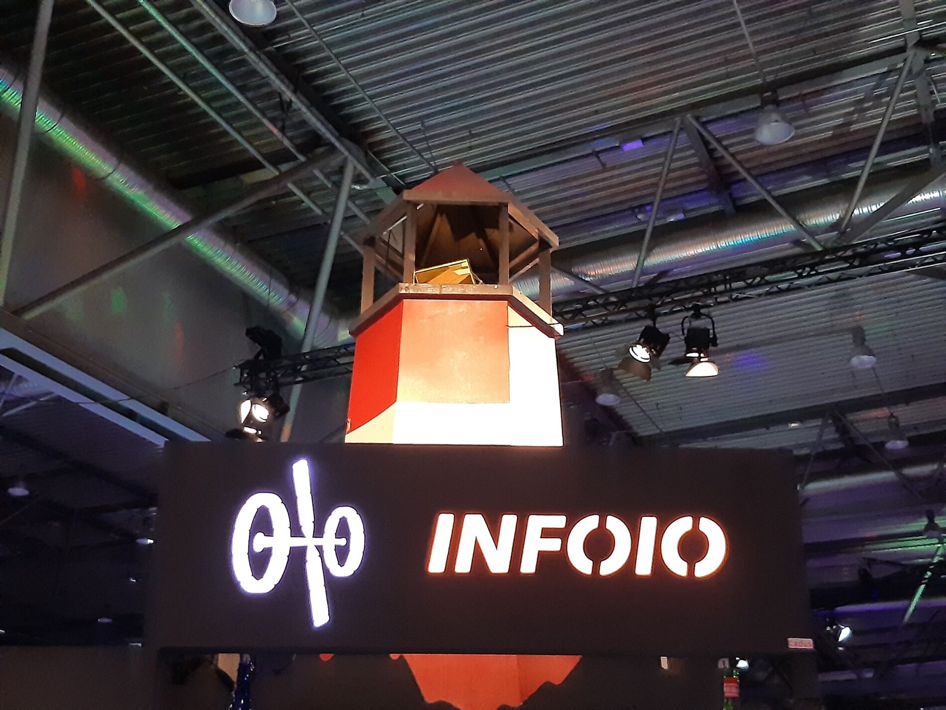 Ein Leuchtturm aus Holz vor einem OIO-Schild in der Kongresshalle.