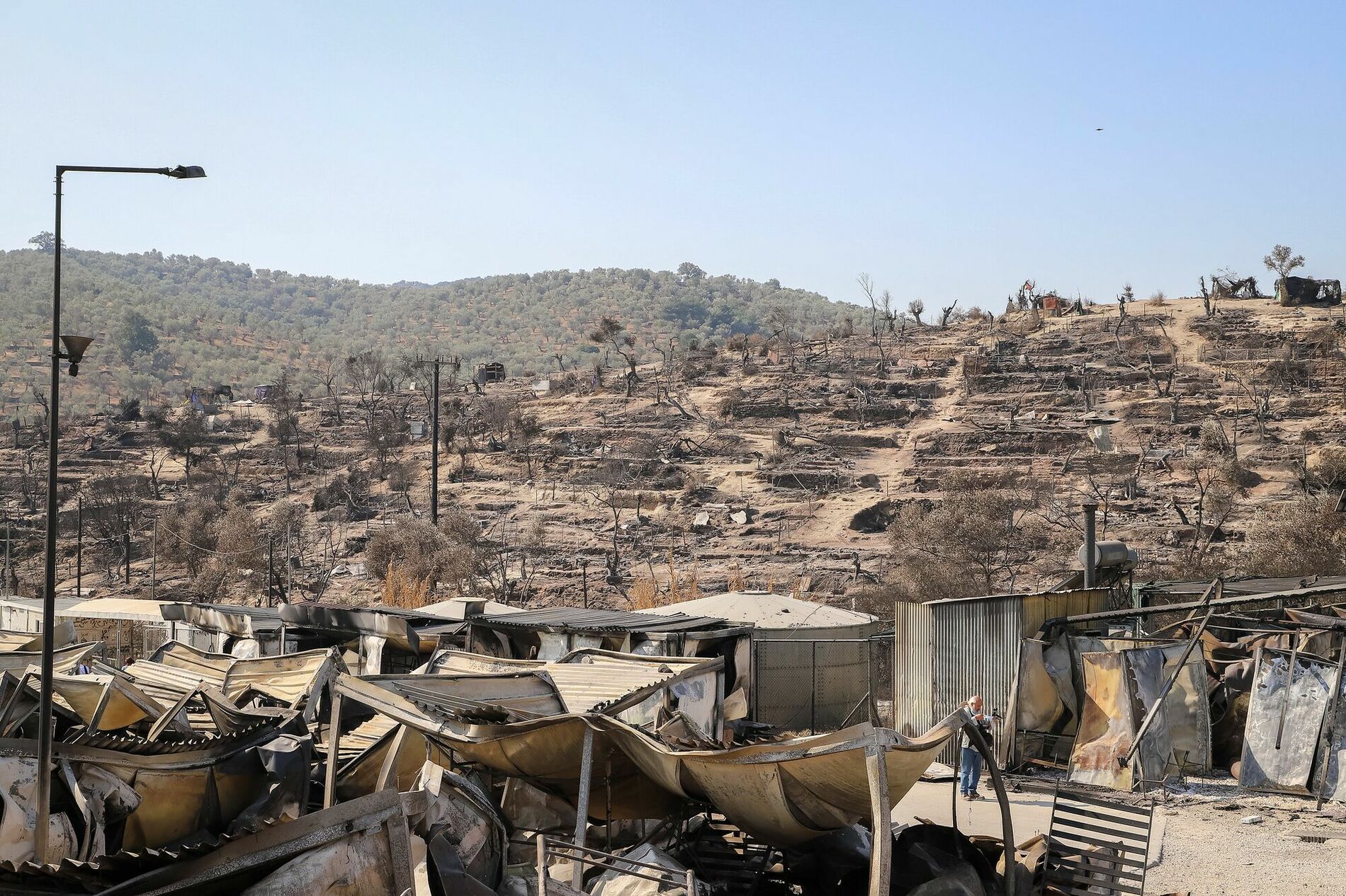 Abgebrannte Hügel mit zerstörten Unterkünften im Geflüchtetenlager Moria auf Lesbos.