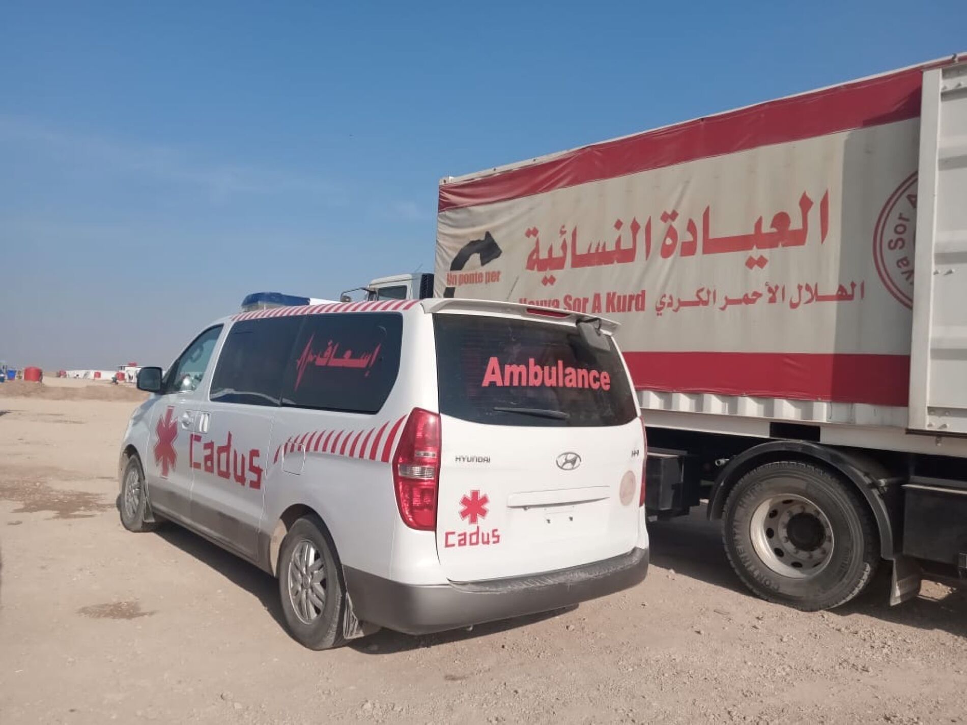 An ambulace from CADUS in front of a truck from Heyva Sor at Tal Tamr.