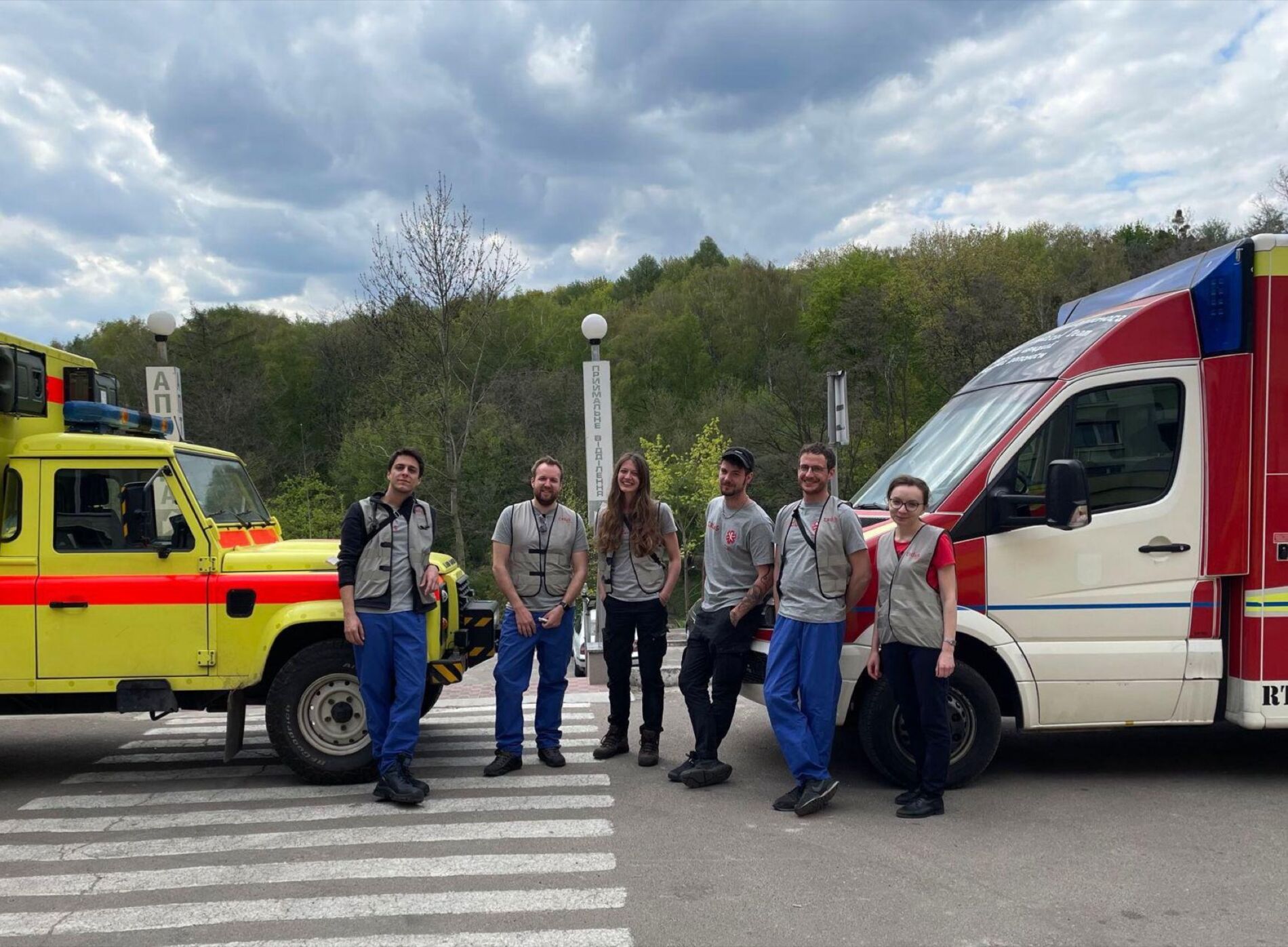 Ein medizinisches Team von CADUS zwischen zwei Rettungswagen.